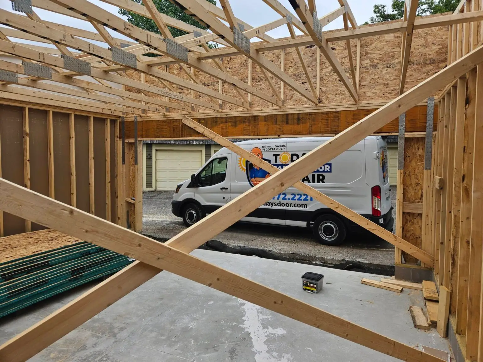 Today's Garage Door Repair van parked outside a new garage under construction