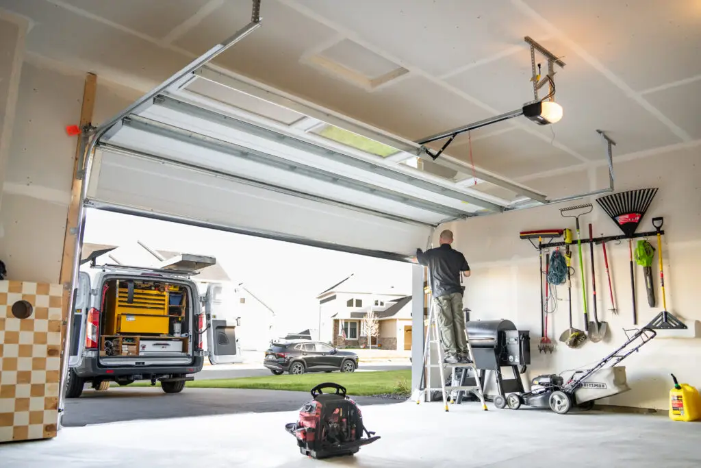 Today's Garage Door Repair technician on a ladder servicing a garage door opener